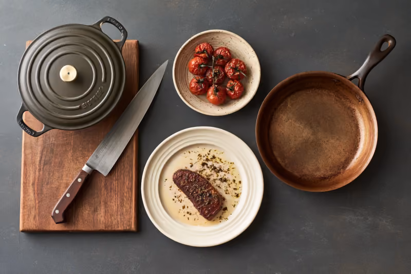 Ustensiles de cuisine posés sur un plan de travail en bois